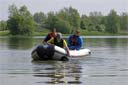 picture of black newfoundland dog collecting tow rope from steward in boat