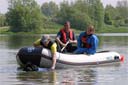 picture of black newfoundland dog towing boat towards shore
