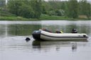 picture of black newfoundland dog having found rope commencing tow of boat to shore
