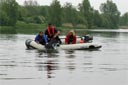 picture of black newfoundland dog being taken aboard second boat
